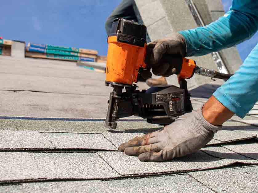 Roof repair crew replacing damaged shingles